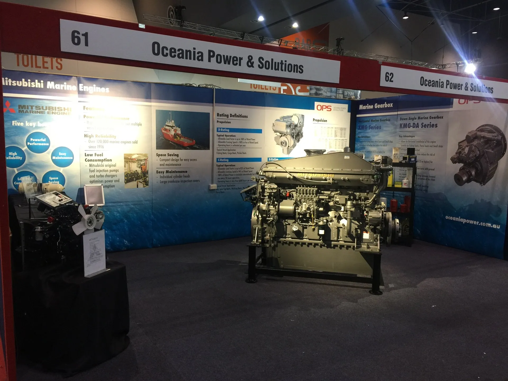 OPS's stand at a marine industry trade show, with a marine engine on display and event signage in the background